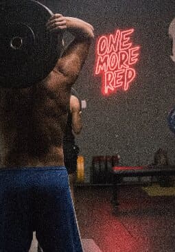 Atleta entrenando junto al letrero One More Rep